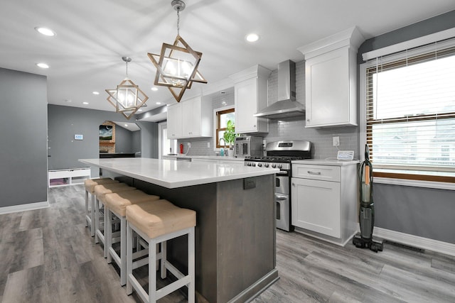 10129 Granden St, Pickerington, OH 43147 - kitchen featuring wall chimney exhaust hood, double oven range, a center island, baseboards, and light countertops