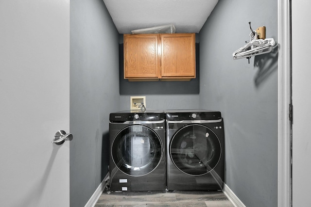 10129 Granden St, Pickerington, OH 43147 - clothes washing area with washer and clothes dryer, cabinet space, baseboards, and wood finished floors