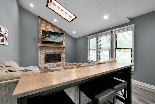 10129 Granden St, Pickerington, OH 43147 - dining room with vaulted ceiling, a brick fireplace, wood finished floors, baseboards, and a skylight