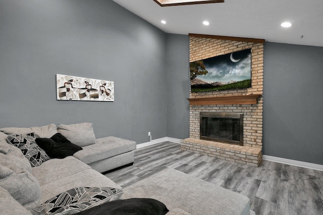 10129 Granden St, Pickerington, OH 43147 - living room with vaulted ceiling, recessed lighting, wood finished floors, baseboards, and a brick fireplace