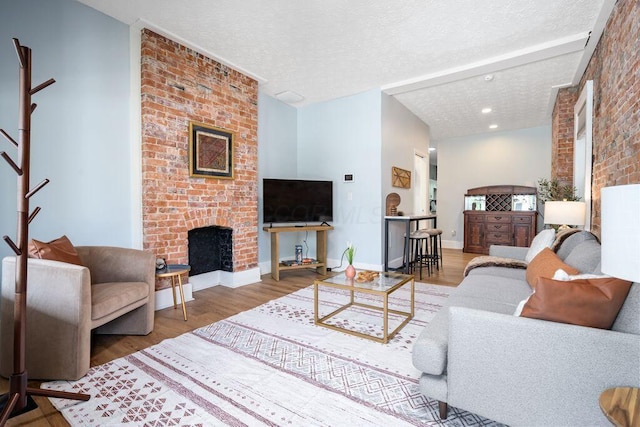 453-455 S 22nd St, Columbus, OH 43205 - living area with wood finished floors, a brick fireplace, a textured ceiling, and baseboards