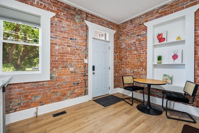 453-455 S 22nd St, Columbus, OH 43205 - entryway with wood finished floors, baseboards, brick wall, and a textured ceiling
