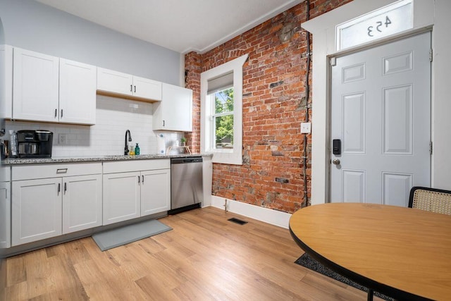 453-455 S 22nd St, Columbus, OH 43205 - kitchen with stainless steel dishwasher, a sink, light wood-type flooring, white cabinets, and tasteful backsplash
