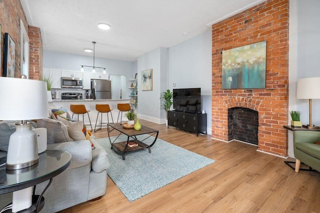 453-455 S 22nd St, Columbus, OH 43205 - living room with light wood-style flooring, a brick fireplace, and baseboards