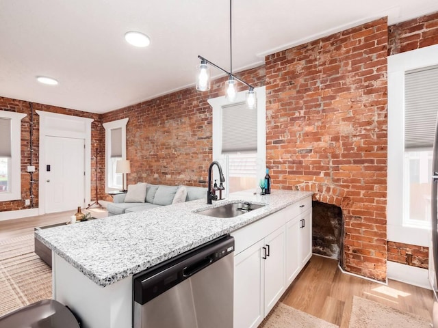 453-455 S 22nd St, Columbus, OH 43205 - kitchen with stainless steel dishwasher, a sink, light wood-type flooring, brick wall, and white cabinetry