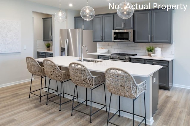 1573 Crest Dr Lot 2560, Galena, OH 43021 - kitchen featuring stainless steel appliances, a sink, an island with sink, light wood-type flooring, and a kitchen breakfast bar