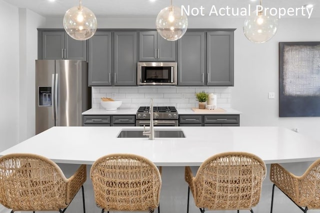 1573 Crest Dr Lot 2560, Galena, OH 43021 - kitchen featuring stainless steel appliances, gray cabinetry, a kitchen bar, and decorative backsplash