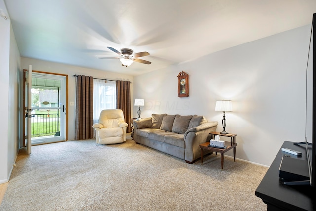 living area with light carpet, ceiling fan, and baseboards