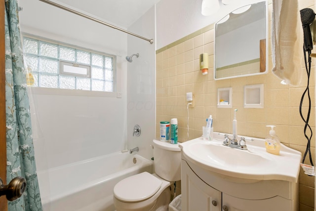 bathroom featuring shower / bath combo, tile walls, toilet, and vanity