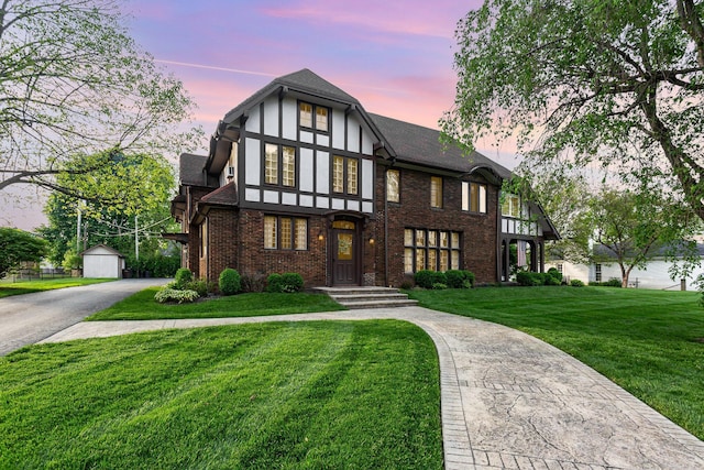 404 Rawling St, Washington Court House, OH 43160 - tudor-style house with a yard, an outbuilding, brick siding, and a shingled roof
