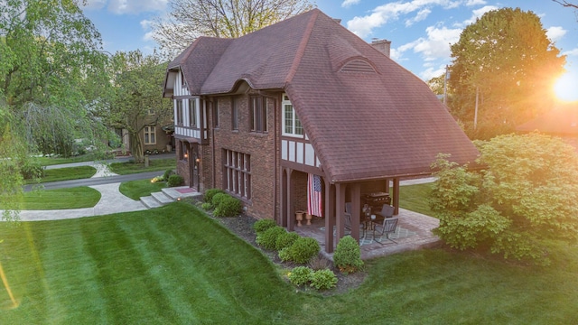404 Rawling St, Washington Court House, OH 43160 - view of property exterior with a chimney, a lawn, a patio, brick siding, and roof with shingles