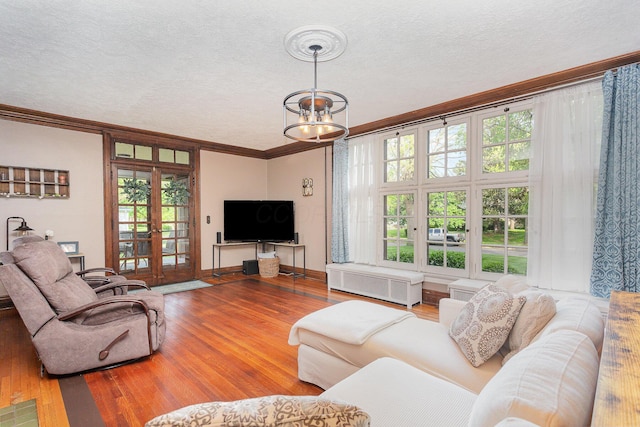 404 Rawling St, Washington Court House, OH 43160 - living area with ornamental molding, wood finished floors, french doors, a chandelier, and a textured ceiling