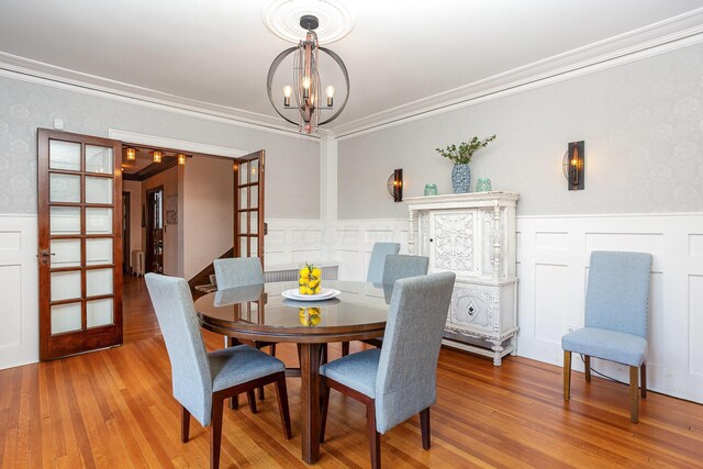404 Rawling St, Washington Court House, OH 43160 - dining space with a chandelier, ornamental molding, a wainscoted wall, light wood-type flooring, and a decorative wall