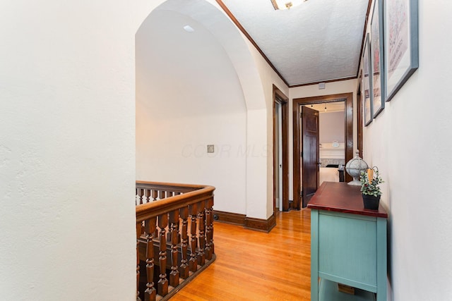 404 Rawling St, Washington Court House, OH 43160 - hallway with arched walkways, light wood-style flooring, baseboards, and a textured ceiling
