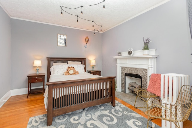 404 Rawling St, Washington Court House, OH 43160 - bedroom with crown molding, wood finished floors, a textured ceiling, baseboards, and a fireplace