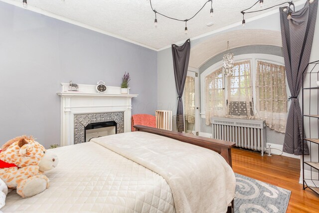 404 Rawling St, Washington Court House, OH 43160 - bedroom with radiator heating unit, ornamental molding, wood finished floors, a chandelier, and a textured ceiling