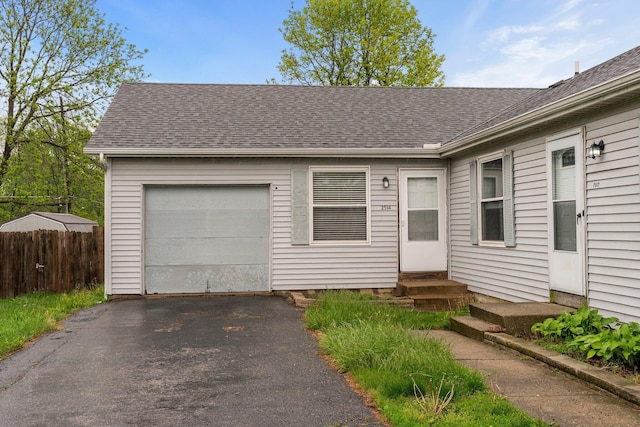 2512 Gantz Rd, Grove City, OH 43123 - view of front of home with asphalt driveway, entry steps, fence, a shingled roof, and a garage