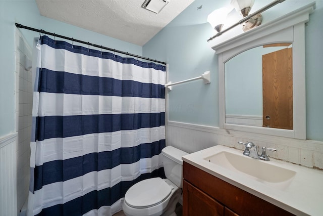 2512 Gantz Rd, Grove City, OH 43123 - bathroom featuring wainscoting, toilet, a textured ceiling, vanity, and curtained shower