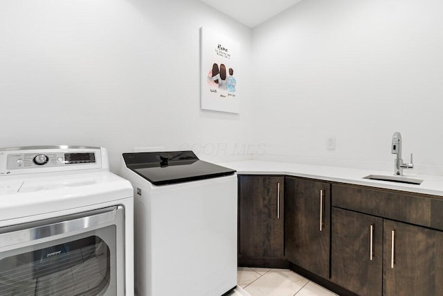 3084 Asbury Dr, Columbus, OH 43221 - washroom featuring washer and clothes dryer, cabinet space, and light tile patterned flooring
