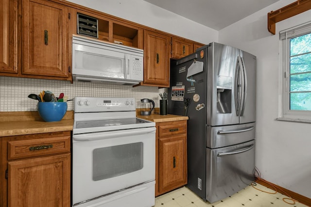 kitchen with white appliances, light floors, brown cabinets, and decorative backsplash