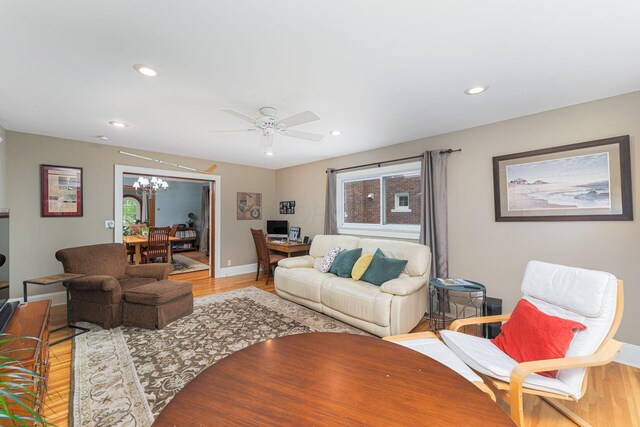 living area with light wood-style floors, a chandelier, plenty of natural light, ceiling fan, and recessed lighting