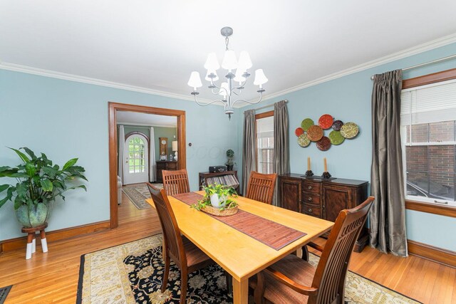 dining area featuring a chandelier, baseboards, ornamental molding, and light wood finished floors