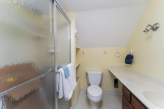 bathroom with a stall shower, vaulted ceiling, vanity, toilet, and tile patterned floors