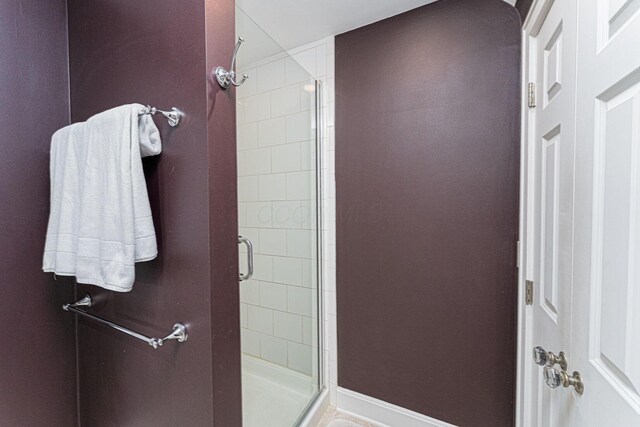 bathroom featuring a stall shower and baseboards
