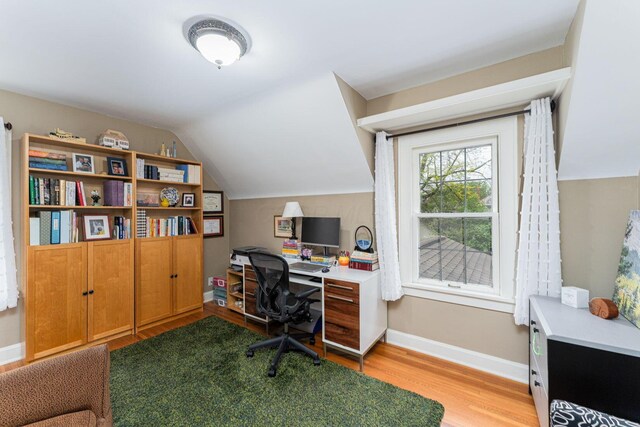 home office with wood finished floors, vaulted ceiling, and baseboards