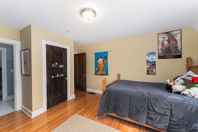 bedroom featuring wood finished floors and baseboards