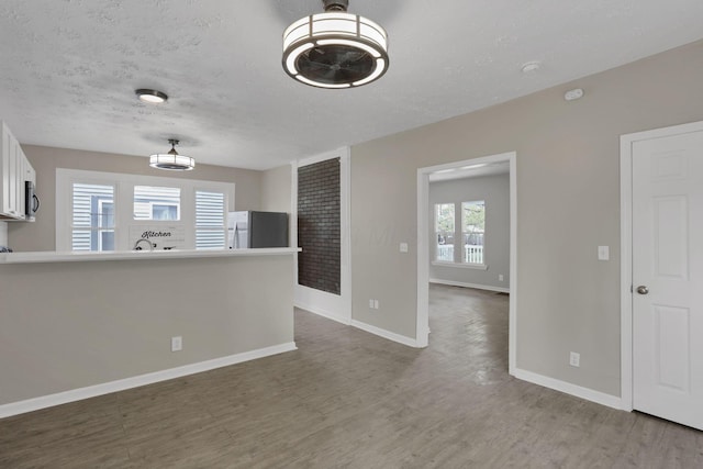 1617 Arlington Ave, Columbus, OH 43211 - spare room with wood finished floors, baseboards, and a textured ceiling
