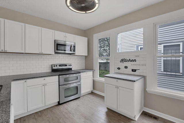 1617 Arlington Ave, Columbus, OH 43211 - kitchen with appliances with stainless steel finishes, white cabinets, light wood finished floors, and tasteful backsplash