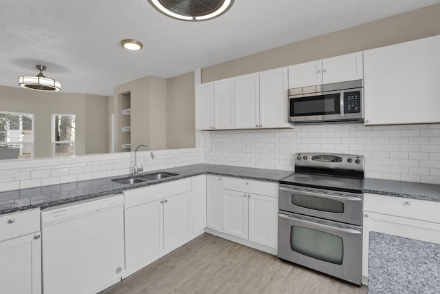 1617 Arlington Ave, Columbus, OH 43211 - kitchen featuring appliances with stainless steel finishes, a sink, white cabinets, light wood finished floors, and dark stone counters