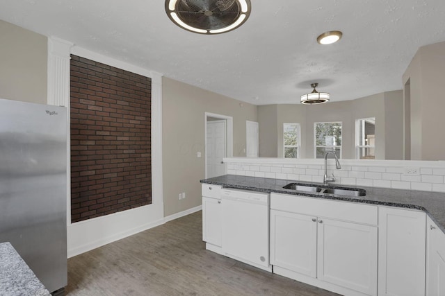 1617 Arlington Ave, Columbus, OH 43211 - kitchen featuring white dishwasher, freestanding refrigerator, a sink, white cabinetry, and wood finished floors