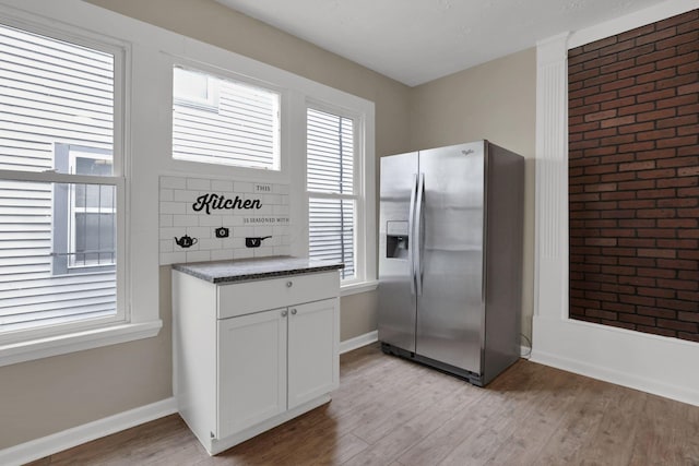 1617 Arlington Ave, Columbus, OH 43211 - kitchen featuring stainless steel fridge with ice dispenser, light wood-type flooring, white cabinetry, and baseboards