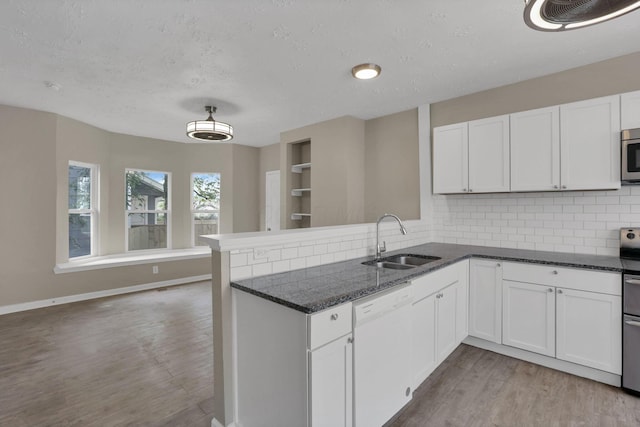 1617 Arlington Ave, Columbus, OH 43211 - kitchen featuring white dishwasher, a sink, a peninsula, wood finished floors, and stainless steel microwave