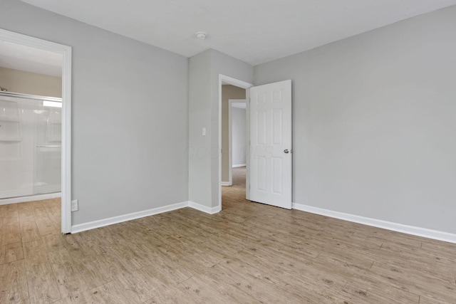 1617 Arlington Ave, Columbus, OH 43211 - unfurnished bedroom featuring wood finished floors, baseboards, and connected bathroom