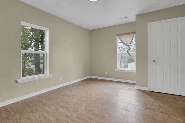 1617 Arlington Ave, Columbus, OH 43211 - empty room with healthy amount of natural light, hardwood / wood-style floors, and baseboards