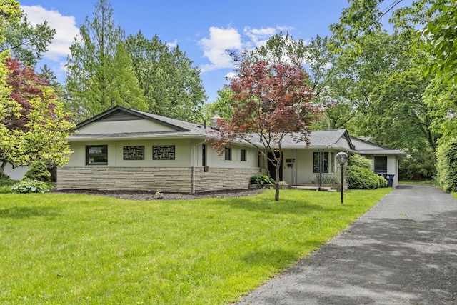 2249 E Broad St, Columbus, OH 43209 - single story home featuring stone siding, a front yard, stucco siding, driveway, and a chimney