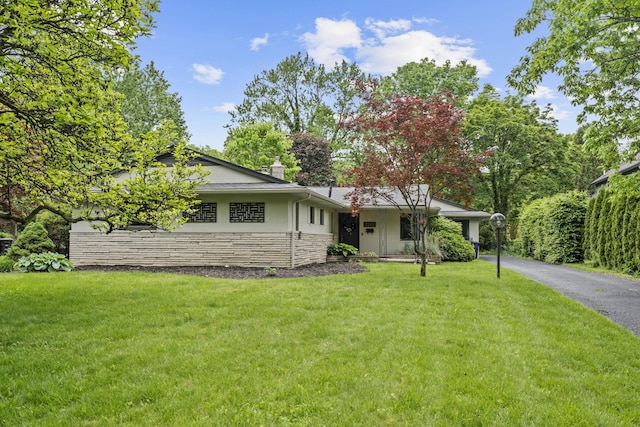 2249 E Broad St, Columbus, OH 43209 - view of front of home with stucco siding, stone siding, a front lawn, and a chimney