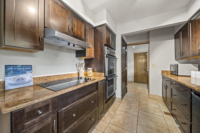 2249 E Broad St, Columbus, OH 43209 - kitchen with under cabinet range hood, black electric cooktop, multiple ovens, dark brown cabinetry, and light stone countertops