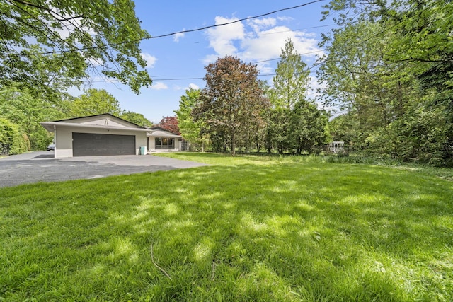 2249 E Broad St, Columbus, OH 43209 - view of green lawn with asphalt driveway and an attached garage