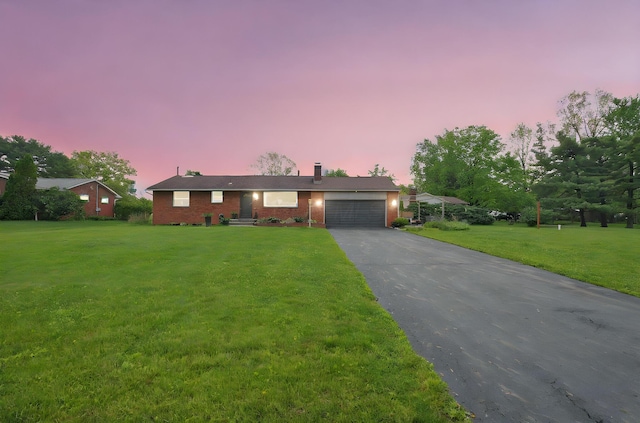 3130 Marwick Rd, Columbus, OH 43232 - single story home featuring asphalt driveway, brick siding, a garage, and a yard