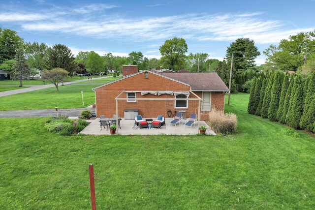 3130 Marwick Rd, Columbus, OH 43232 - rear view of property featuring a patio, a chimney, a lawn, and brick siding