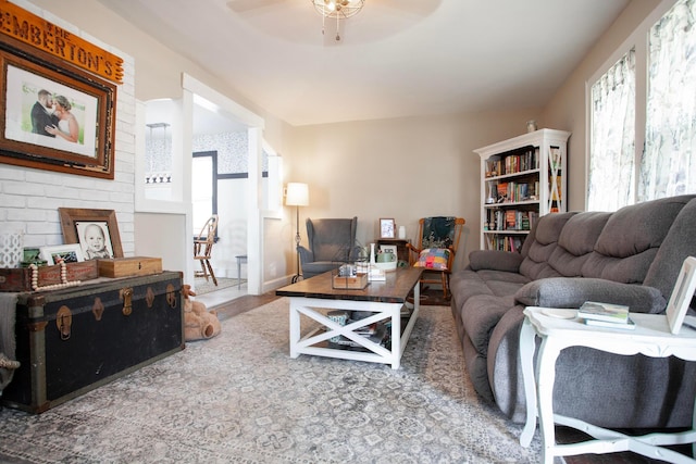 living area featuring a ceiling fan, wood finished floors, and a fireplace