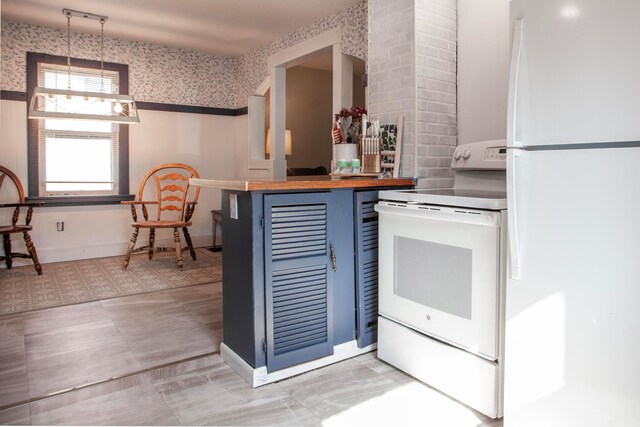 kitchen featuring white appliances, blue cabinets, wallpapered walls, wooden counters, and pendant lighting