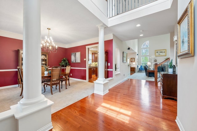 6674 Letterman Dr, Powell, OH 43065 - foyer entrance with decorative columns, light wood-style flooring, crown molding, baseboards, and a chandelier