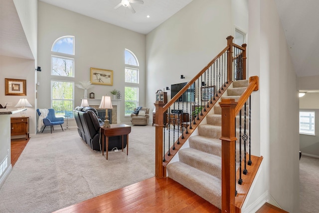 6674 Letterman Dr, Powell, OH 43065 - staircase with a towering ceiling, a ceiling fan, hardwood / wood-style floors, and baseboards