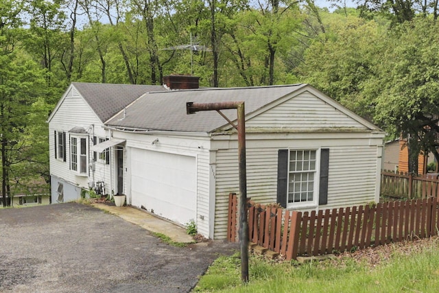 1525 Krebs Dr, Newark, OH 43055 - view of front of property featuring a garage, driveway, fence, roof with shingles, and a chimney