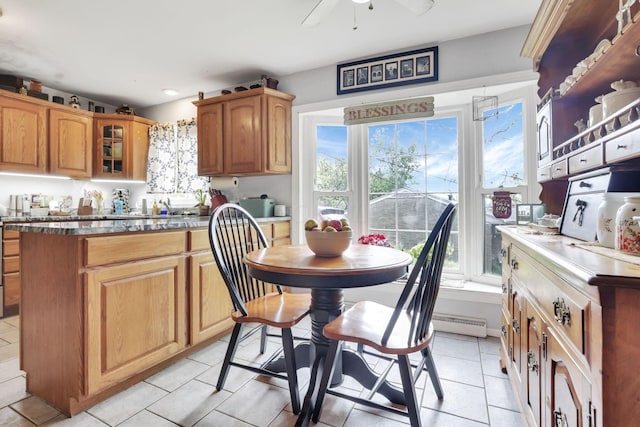 1525 Krebs Dr, Newark, OH 43055 - kitchen featuring light tile patterned floors, glass insert cabinets, a ceiling fan, and brown cabinetry